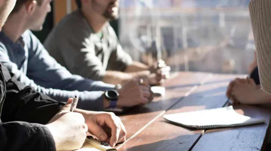Group of office workers sitting at table discussing.