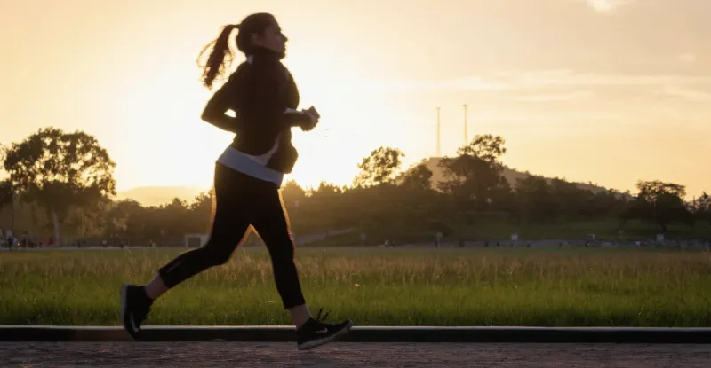 Energetic woman jogging in the sunrise.