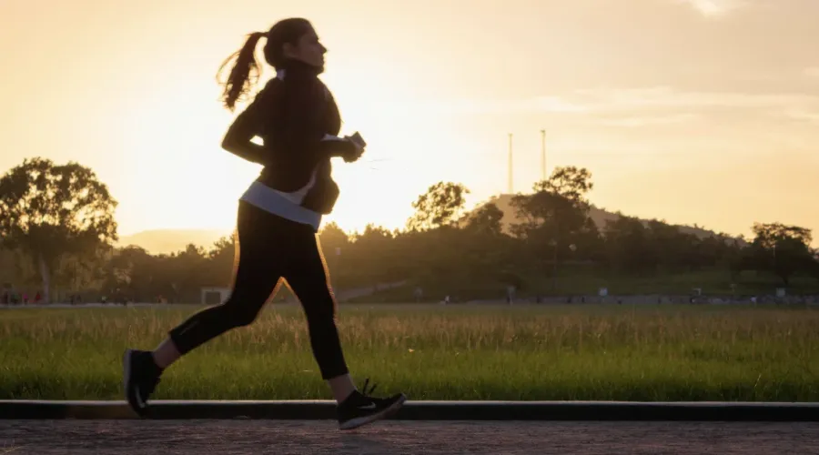Energetic woman jogging in the sunrise.